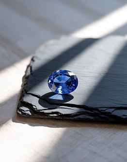 Ceylon blue sapphire gemstone on slate in natural light with soft shadows